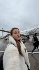 Woman photographs herself at Podgorica Airport with Turkish Airlines plane