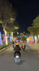 Nighttime motorbike traffic observed on lit street in Vietnam
