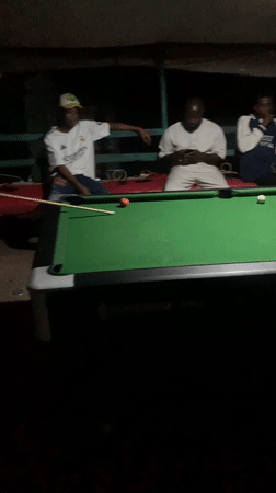 Lokoja streets at night: vendors, pool tables, and passing traffic