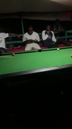 Lokoja streets at night: vendors, pool tables, and passing traffic