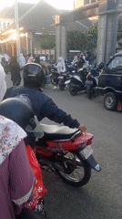 Morning street activity in Ganjaran, Indonesia amid motorcycles and modest dress