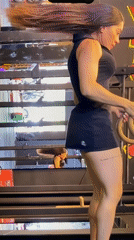 Woman combines treadmill workout with gymnastics rings at gym