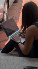 Woman uses laptop on concrete steps in Puebla