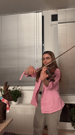 Woman plays violin indoors in Saarbrücken evening session