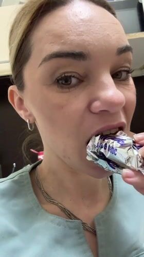 Woman eats coffee-flavored chocolate bar in Vsevolozhsk, Russia