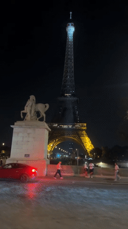 Paris nighttime: Eiffel Tower sparkles, motorcycle rides through streets