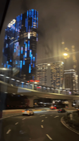 Night driving footage captures illuminated Macao cityscape with blue lights