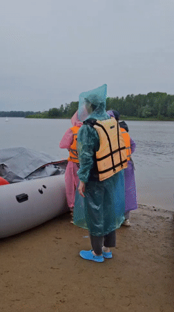 Rainy-day rafting launch on a Russian riverbank