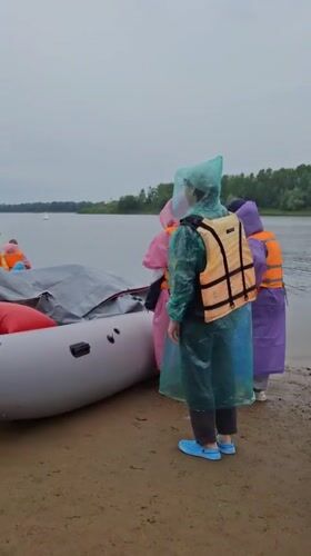 Rainy-day rafting launch on a Russian riverbank