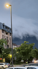 Storm clouds gather over Kragujevac as streetlights illuminate