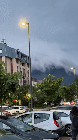 Storm clouds gather over Kragujevac as streetlights illuminate