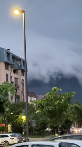 Storm clouds gather over Kragujevac as streetlights illuminate