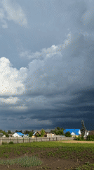 Storm clouds gathering over rural farmland