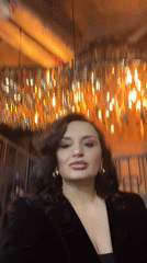 Woman records selfie video in decorated interior space