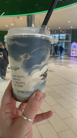 Person holds artistic beverage cup in Minsk building