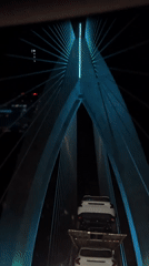 Car carrier crosses illuminated bridge in Morocco at night