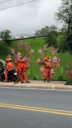 Sanitation workers take break on Da Lat sidewalk