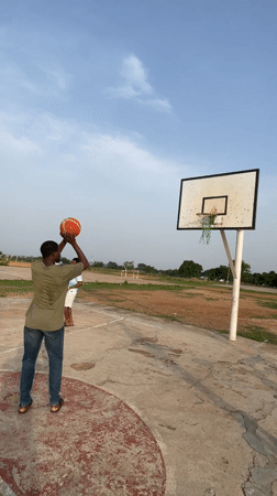 Men play basketball on outdoor court in Akwanga, Nigeria