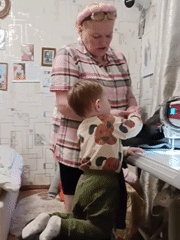 Grandmother and toddler share sewing time in Russian village