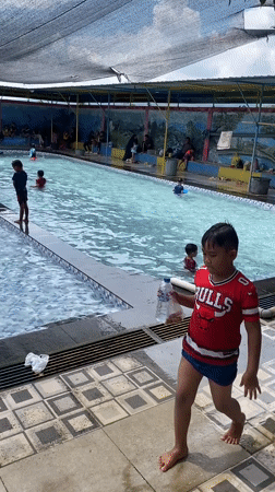 Crowded water park day with slides and kids in the pool