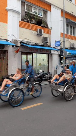 Cyclos rolling through a commercial street in Thủ Đức