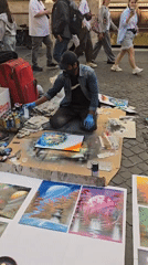 Street artists perform spray paint art and violin in Rome