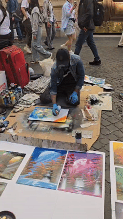 Street artists perform spray paint art and violin in Rome