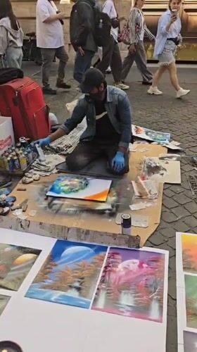 Street artists perform spray paint art and violin in Rome