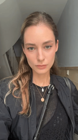 Woman photographed in Kiel stairwell adjusting hair, posing