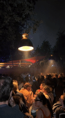 Large nighttime outdoor party observed in Copenhagen with DJ stage