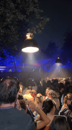 Large nighttime outdoor party observed in Copenhagen with DJ stage