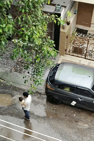 Rainy morning across a Gurgaon neighborhood, rooftops to street level