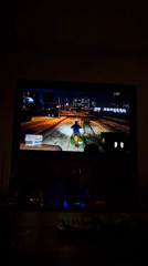Late-night GTA V motorcycle gameplay on a large screen