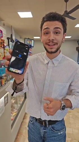 Young man uses contactless payment at Corsico store