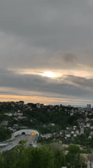 Aerial view captures sunlight breaking through clouds over valley city