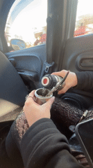 Person prepares traditional mate drink inside car in Buenos Aires