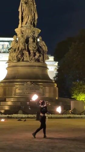 Fire poi performance in front of a classical monument, St. Petersburg