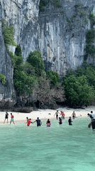Morning beach activities captured at Ao Nang's limestone cliffs