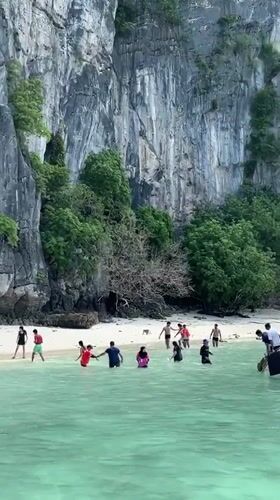 Morning beach activities captured at Ao Nang's limestone cliffs