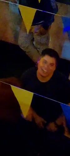 Man works on technical device during festive gathering in Arica
