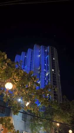 Blue neon-lit building observed at night in Vietnam