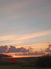 Tallinn sunset across water, fields, and open road
