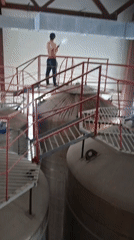 Worker pressure-washes industrial tanks at Kokshetau facility