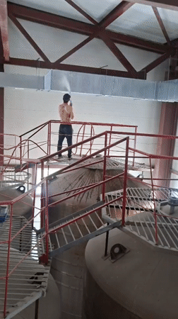 Worker pressure-washes industrial tanks at Kokshetau facility
