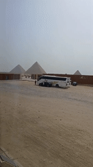 Tourist buses, visitors gather at Great Pyramid under hazy skies