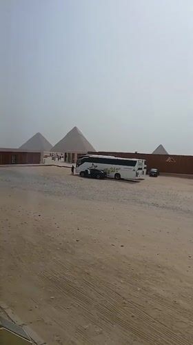 Tourist buses, visitors gather at Great Pyramid under hazy skies