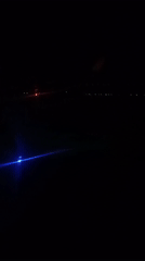 Passenger films nighttime aerial view over Kuta, Indonesia