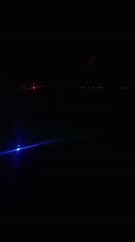 Passenger films nighttime aerial view over Kuta, Indonesia