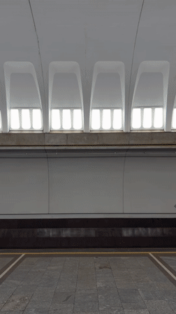 Blue subway train 1497 carries passengers through Minsk station
