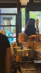 Service worker tends counter with dishes in London